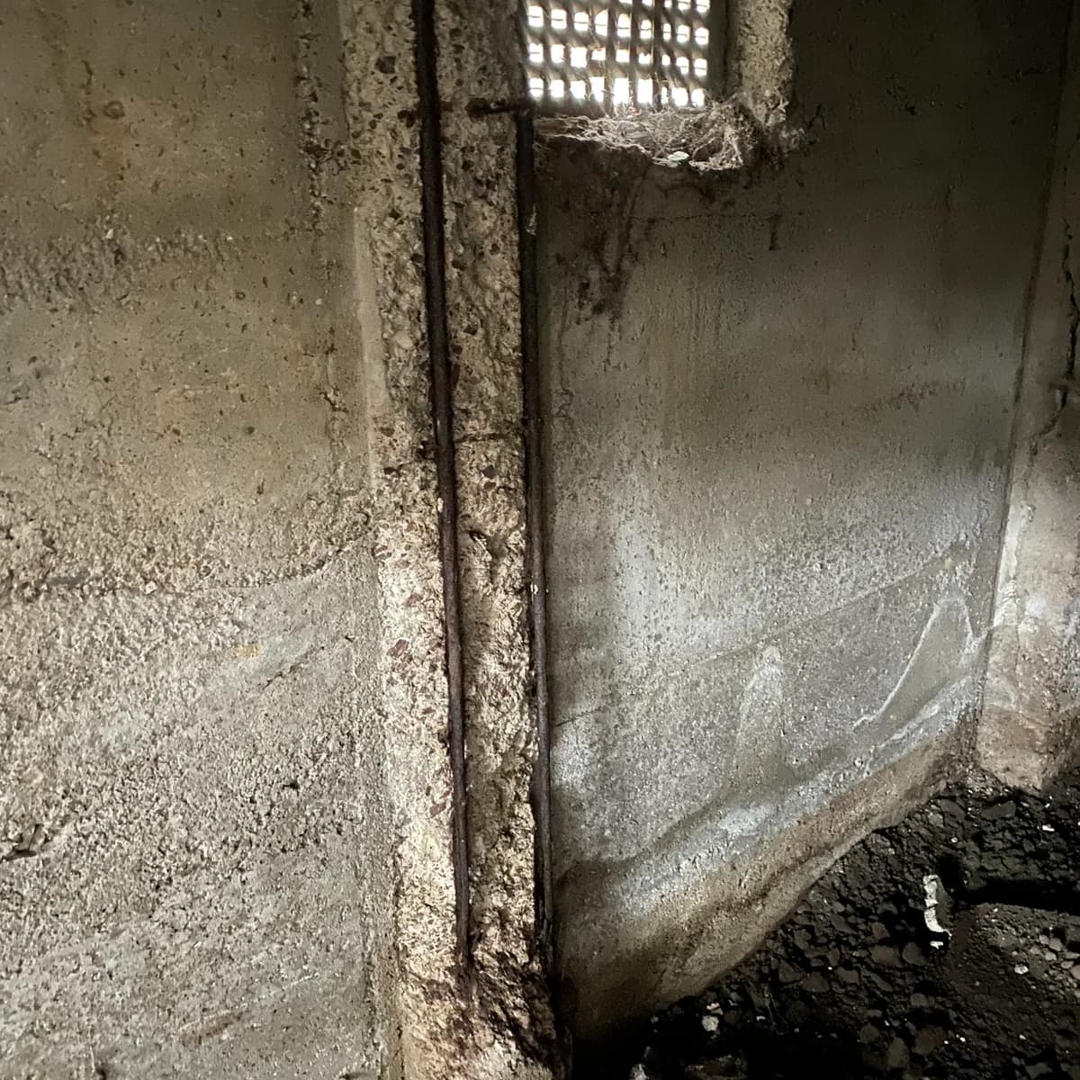 Spalling concrete and exposed reinforcement at a support
