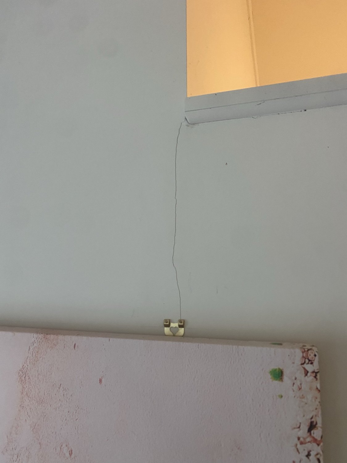 Internal hairline crack extending from a door or window opening